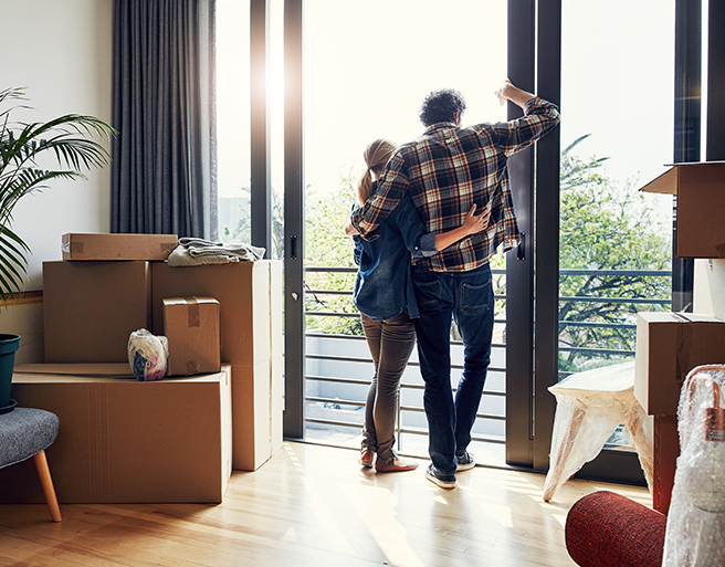 Product-Homeowners middle aged couple surrounded by moving boxes in new condo